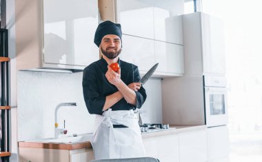 Üniformalı profesyonel aşçı mutfakta salata yapıyor..