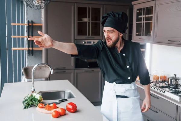 Üniformalı profesyonel aşçı mutfakta salata yapıyor..