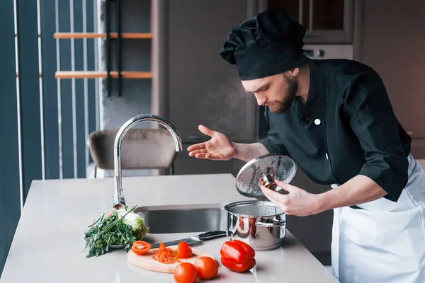 Mutfakta duran üniformalı profesyonel aşçı..