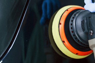 Yeni modern arabaları cilalayan üniformalı bir erkek işçi. Hizmet kavramı.