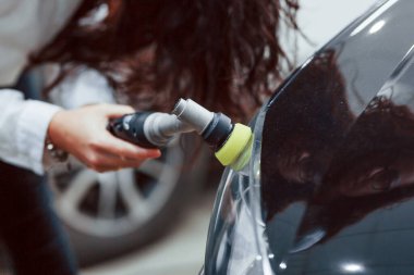 Modern otomobili temizleyen ekipmanlı kadın. Hizmet kavramı.