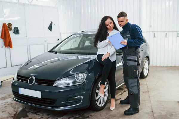 Female customer takes back her auto in car washing service.