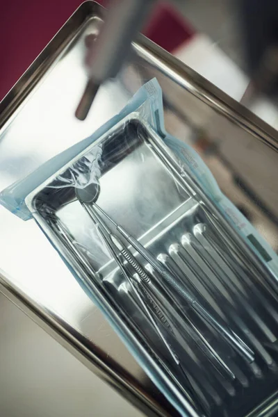 Klinikteki yeni paketin içindeki farklı diş aletlerinin üst görünümü.