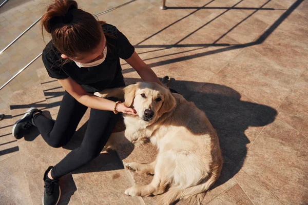 Koruyucu maskeli genç bir kadın karantina zamanında iş yerinin yakınında dışarıda yürüyüş yapıyor. Koronavirüs kavramı.