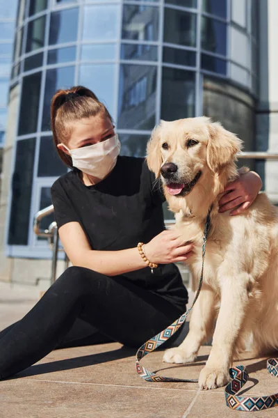 Koruyucu maskeli genç bir kadın karantina zamanında iş yerinin yakınında dışarıda yürüyüş yapıyor. Koronavirüs kavramı.