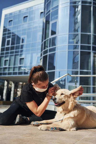 Koruyucu maskeli genç bir kadın karantina zamanında iş yerinin yakınında dışarıda yürüyüş yapıyor. Koronavirüs kavramı.