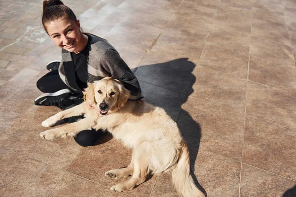 Genç pozitif kadın dışarıda dolaşırken köpeğiyle eğleniyor..