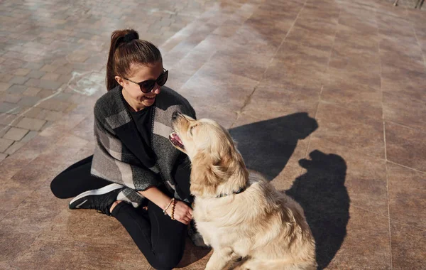 Genç pozitif kadın dışarıda dolaşırken köpeğiyle eğleniyor..