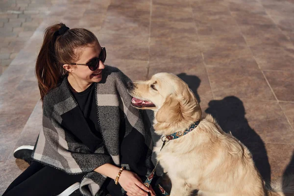 Genç pozitif kadın dışarıda dolaşırken köpeğiyle eğleniyor..