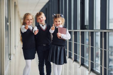 Okul üniformalı çocuklar koridorda beraberler. Eğitim kavramı.