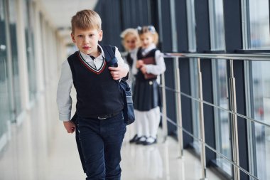 Okul üniformalı çocuklar koridorda beraberler. Eğitim kavramı.