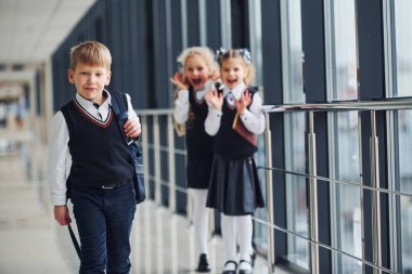 Okul üniformalı çocuklar koridorda beraberler. Eğitim kavramı.