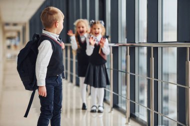 Okul üniformalı çocuklar koridorda beraberler. Eğitim kavramı.
