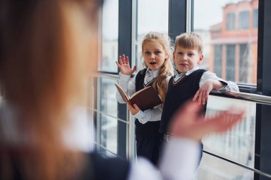 Okul üniformalı çocuklar koridorda beraberler. Eğitim kavramı.