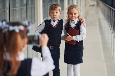 School kids in uniform making a photo together in corridor. Conception of education.