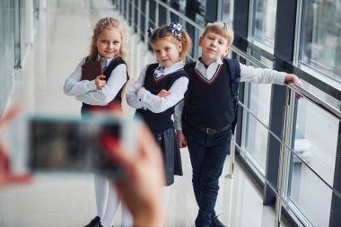 School kids in uniform making a photo together in corridor. Conception of education.