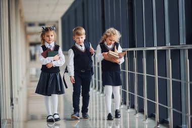 Okul üniformalı çocuklar koridorda beraberler. Eğitim kavramı.