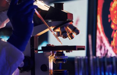 Beyaz koruyucu üniforma giyen bilim adamları verilerle birlikte laboratuvarda koronavirüs ve kan tüpleriyle çalışıyorlar..