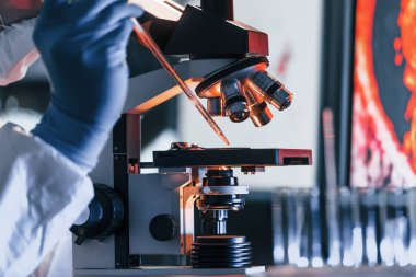 Beyaz koruyucu üniforma giyen bilim adamları verilerle birlikte laboratuvarda koronavirüs ve kan tüpleriyle çalışıyorlar..