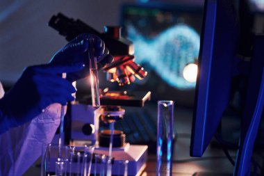 Beyaz koruyucu üniformalı bilim adamları laboratuarda koronavirüs ve kan tüpleriyle çalışıyorlar..