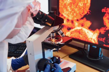 Laboratuvarda koronavirüsle çalışan koruyucu üniformalı bilim adamına yakından bakın..