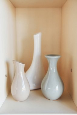 İç mekandaki duvarın içinde duran üç vazo..