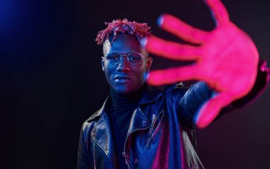 Eğleniyorum. Fütürist neon ışıkları. Stüdyodaki Afrikalı Amerikalı genç adam..