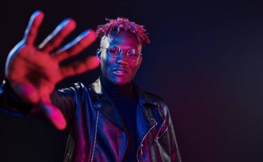 Eğleniyorum. Fütürist neon ışıkları. Stüdyodaki Afrikalı Amerikalı genç adam..