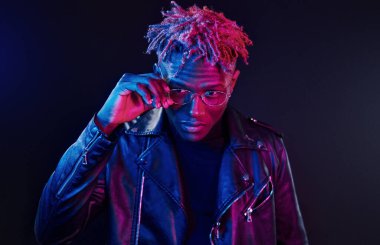 Eğleniyorum. Fütürist neon ışıkları. Stüdyodaki Afrikalı Amerikalı genç adam..