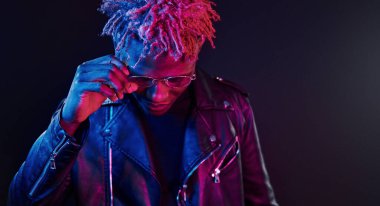 Eğleniyorum. Fütürist neon ışıkları. Stüdyodaki Afrikalı Amerikalı genç adam..