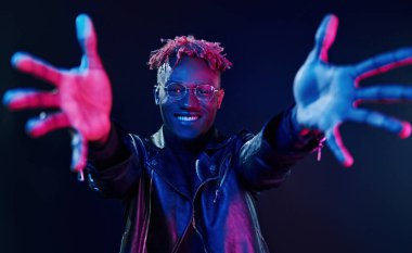 Eğleniyorum. Fütürist neon ışıkları. Stüdyodaki Afrikalı Amerikalı genç adam..