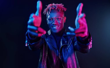 Eğleniyorum. Fütürist neon ışıkları. Stüdyodaki Afrikalı Amerikalı genç adam..