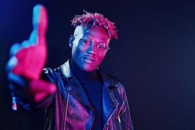 Eğleniyorum. Fütürist neon ışıkları. Stüdyodaki Afrikalı Amerikalı genç adam..