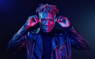 Eğleniyorum. Fütürist neon ışıkları. Stüdyodaki Afrikalı Amerikalı genç adam..