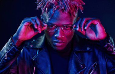 Eğleniyorum. Fütürist neon ışıkları. Stüdyodaki Afrikalı Amerikalı genç adam..