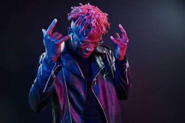Eğleniyorum. Fütürist neon ışıkları. Stüdyodaki Afrikalı Amerikalı genç adam..