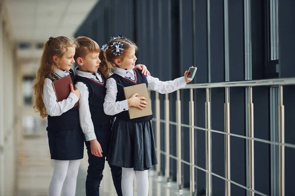 Školáci Uniformě Spolu Telefonem Dělat Selfie Chodbě Koncepce Vzdělávání — Stock fotografie