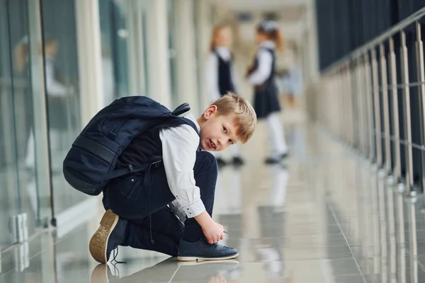 Αγόρι Κάθεται Στο Πάτωμα Μαθητές Στολή Μαζί Στο Διάδρομο — Φωτογραφία Αρχείου