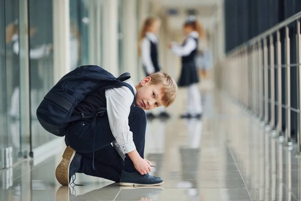 Rapaz Sentado Chão Escolares Uniforme Juntos Corredor — Fotografia de Stock