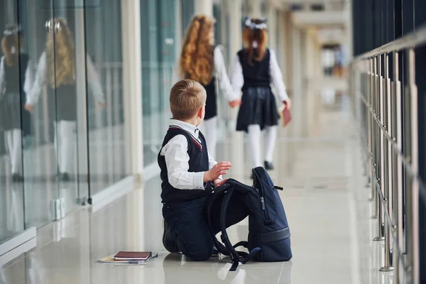 Pojken Sitter Golvet Skolbarn Uniform Tillsammans Korridoren — Stockfoto