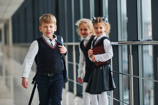 在走廊里 穿着制服的学童一起上学 教育的概念 — 图库照片
