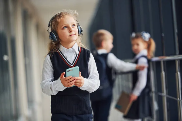 Menina Com Telefone Fones Ouvido Frente Crianças Escola Uniforme Que — Fotografia de Stock