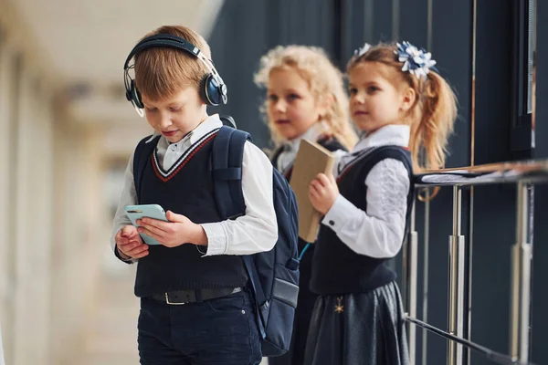 Menino Com Telefone Fones Ouvido Frente Crianças Escola Uniforme Que — Fotografia de Stock
