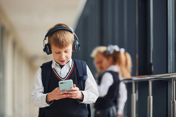 Menino Com Telefone Fones Ouvido Frente Crianças Escola Uniforme Que — Fotografia de Stock