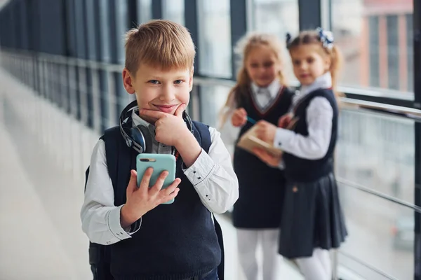 Kleiner Junge Mit Telefon Und Kopfhörer Der Vor Schulkindern Uniform — Stockfoto