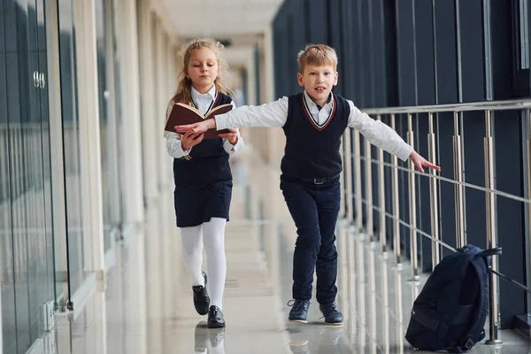 Okul üniformalı çocuklar koridorda beraberler. Eğitim kavramı.