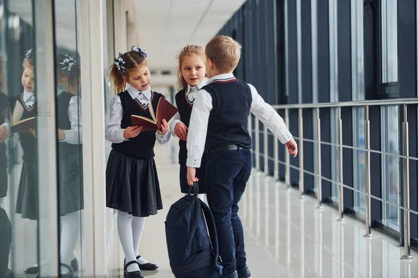 School kids in uniform together in corridor. Conception of education.