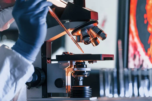 Beyaz koruyucu üniforma giyen bilim adamları verilerle birlikte laboratuvarda koronavirüs ve kan tüpleriyle çalışıyorlar..