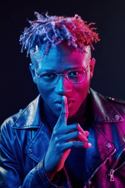 Gözlüklü. Fütürist neon ışıkları. Stüdyodaki Afrikalı Amerikalı genç adam..