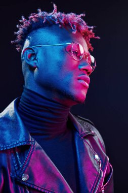 Gözlüklü. Fütürist neon ışıkları. Stüdyodaki Afrikalı Amerikalı genç adam..
